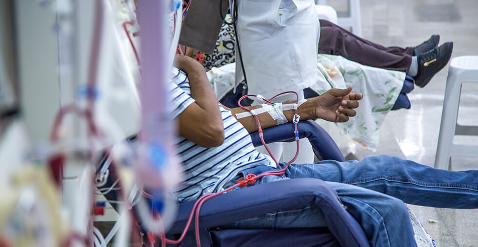 A man sits in a chair for hemodialysis treatment